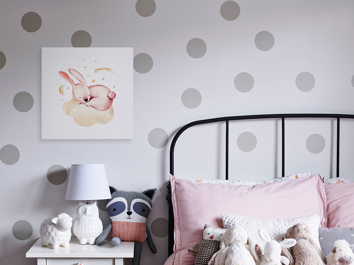 A canvas print above a nightstand beside a child's bed