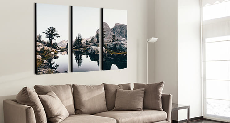 A triptych canvas print displayed over a couch.